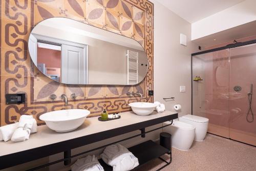 a bathroom with two sinks and a mirror at VIS Urban Suites&Spa in Bari