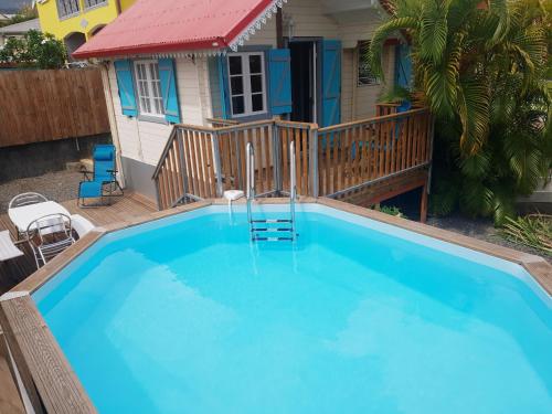 a large blue swimming pool in front of a house at Ti caze des papayes in Saint-Louis