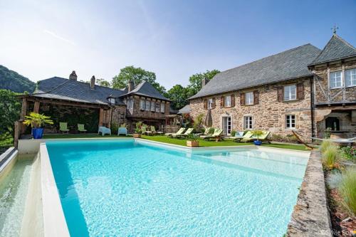 une grande piscine en face d'une maison dans l'établissement Château de Longcol, à La Fouillade
