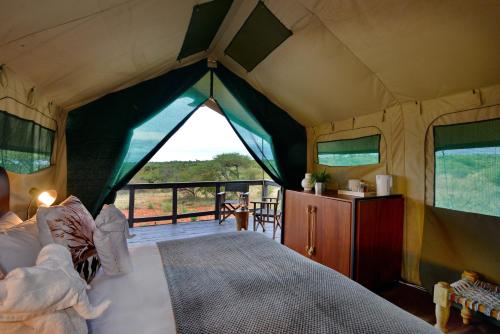 a tent bedroom with a bed and a balcony at Tshukudu Game Lodge in Hoedspruit