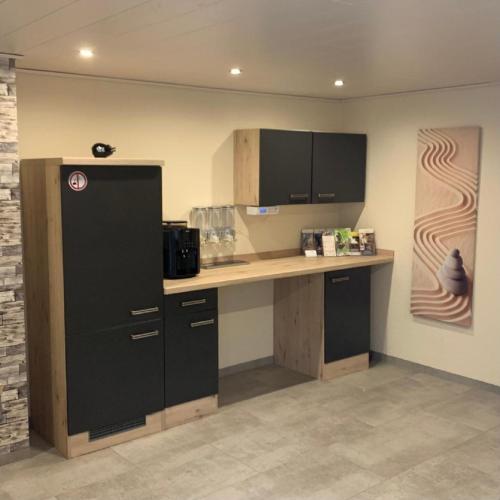 a kitchen with black cabinets and a counter top at Apartment & Klang in Bad Staffelstein