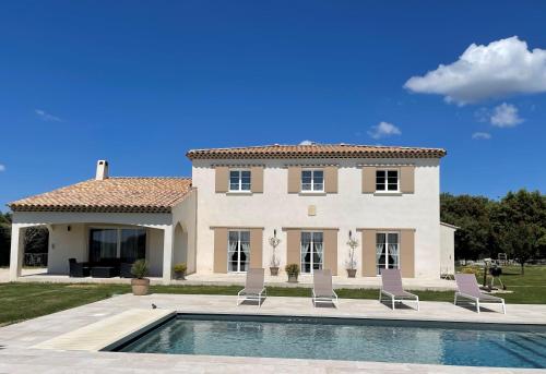 a house with a swimming pool in front of a house at La Bastide Cezanne Natural elegance in Aix-en-Provence