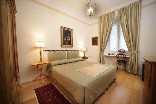 トリエステにあるレジデンツァ レ 6 Aのベッドルーム1室(ベッド1台、テーブル、窓付)
