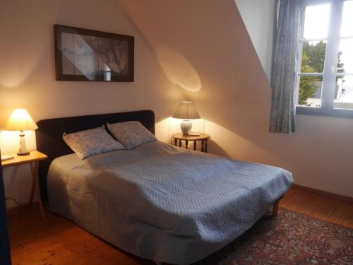 ein Schlafzimmer mit einem Bett, zwei Lampen und einem Fenster in der Unterkunft Maison Le Palais, 5 pièces, 8 personnes - FR-1-418-3 in Le Palais