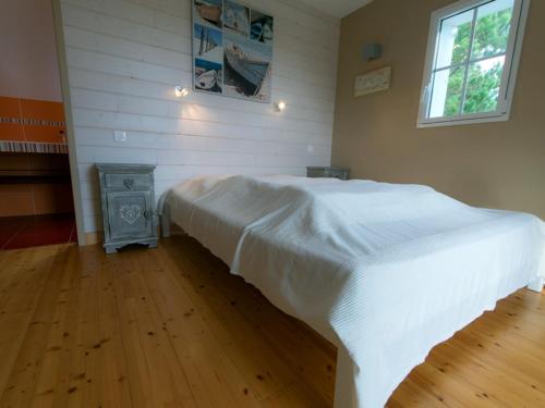 een slaapkamer met een wit bed en een houten vloer bij Maison Bangor, 5 pièces, 8 personnes - FR-1-418-6 in Bangor
