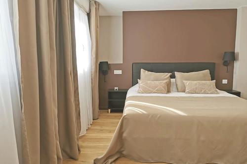 a bedroom with a large bed and a window at Appart Hotel Spa Perpignan in Perpignan
