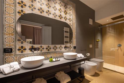 a bathroom with two sinks and a mirror at VIS Urban Suites&Spa in Bari