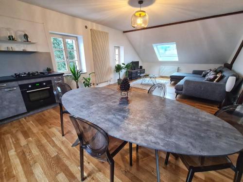 uma cozinha e sala de estar com mesa e cadeiras em l'Alchimiste em Bitche