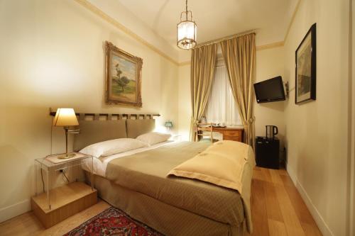 a bedroom with a large bed and a tv at Residenza Le 6 A in Trieste