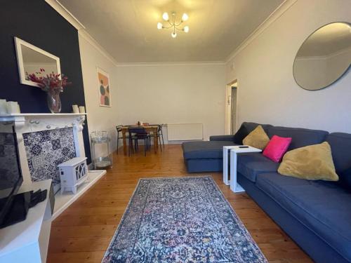 uma sala de estar com um sofá azul e uma lareira em Irongray House em Glasgow