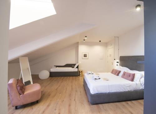 a bedroom with a bed and a couch and a chair at San Carlo Suite Torino in Turin