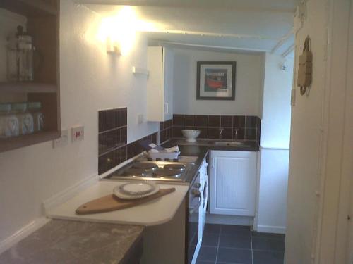 a kitchen with a sink and a stove top oven at Water's View Cottage, Hayle in Hayle