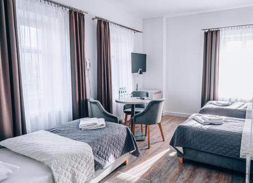 a hotel room with two beds and a desk at Hotel Stronie in Stronie Śląskie