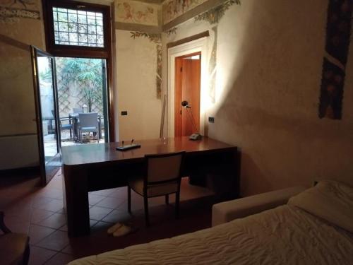 uma secretária com uma cadeira num quarto com uma cama em Palazzo cinquecentesco con giardino interno em Verona