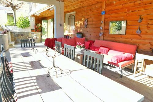 Elle comprend une terrasse dotée d'un mobilier rouge sur un mur en bois. dans l'établissement L'Oustaou Dorey, à Saint-Cyr-sur-Mer