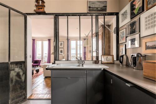 une cuisine avec un évier et un plan de travail dans l'établissement Veeve - Creative Paradise in Bastille, à Paris