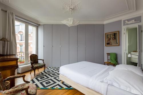 une chambre avec un lit blanc et une fenêtre dans l'établissement Veeve - Creative Paradise in Bastille, à Paris