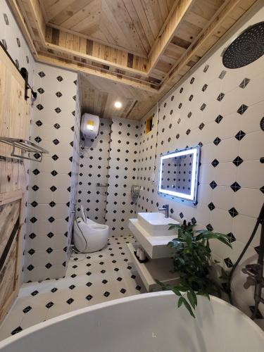 a bathroom with a white tub and a sink at Lightning House in Da Lat
