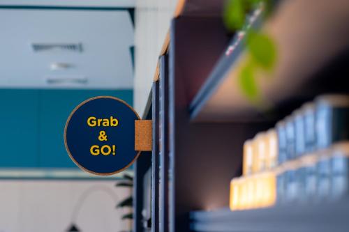 a sign that says grab and go next to a book at GO Hotel Bowin at Robinson Lifestyle Bowin in Si Racha