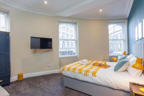 Schlafzimmer mit einem Bett und einem Flachbild-TV in der Unterkunft Royal 2bed apartment City Center in Edinburgh