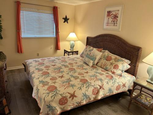 a bedroom with a bed with a floral bedspread at Thunder Island 157D condo in Ocean City