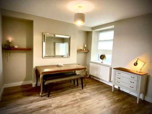 a room with a table and a mirror and a dresser at Three bed, forest view home in Cwmcarn