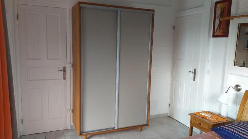 a white closet with a glass door in a room at Nouveau logement T2 avec vue sur mer et montagne in Sainte-Rose