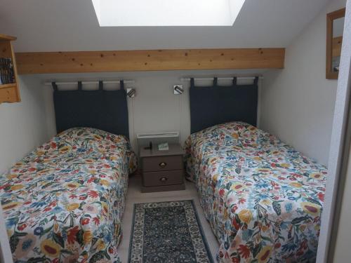 - une chambre avec 2 lits et une table de nuit avec un lit dans l'établissement Duplex 4 pièces avec piscine, parking couvert et Wi-Fi gratuit - FR-1-636-161, à Orcières