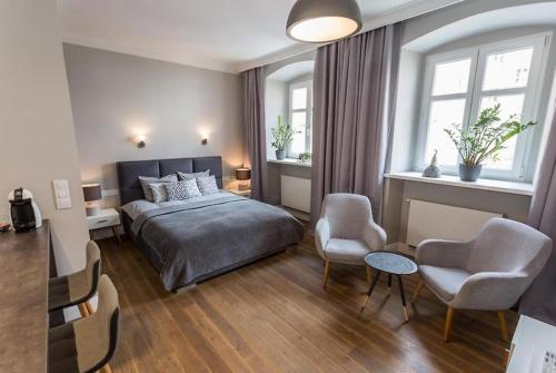 a bedroom with a bed and two chairs and a table at Muzyczna Oaza Przy Rynku in Wrocław