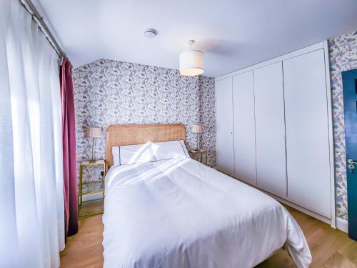 a bedroom with a white bed and a window at The Kinsale 4 Center in Kinsale