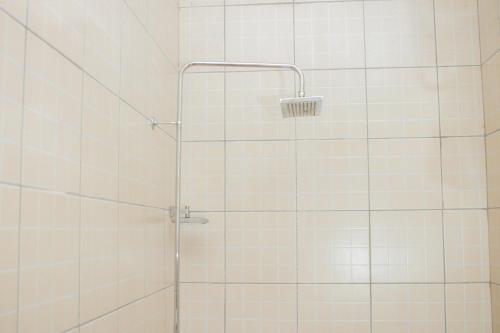 y baño con ducha y azulejos blancos. en Krisstar Lodge en Blantyre