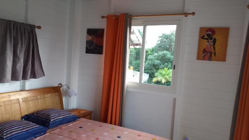 1 dormitorio con cama y ventana en Nouveau logement T2 avec vue sur mer et montagne en Sainte-Rose