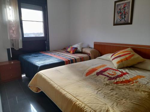 a hotel room with two beds and a window at Deltebre Riu in Deltebre