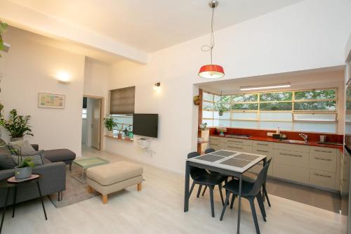 a kitchen and living room with a table and chairs at 9 Sderot Chen - By Beach Apartments TLV in Tel Aviv