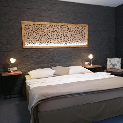a bedroom with a large bed and two tables with lamps at Haus Hubertus in Hochfilzen