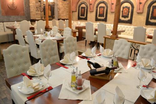 a dining room with white tables and white chairs at Hotel Tomce Sofka in Skopje