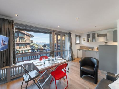 - un salon avec une table, des chaises et une grande fenêtre dans l'établissement Appartement central à Courchevel 1650 avec accès direct aux pistes et WiFi - FR-1-563-117, à Courchevel