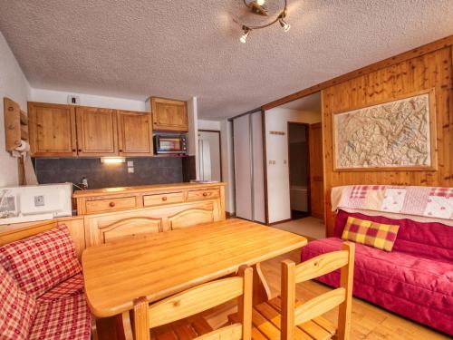une cuisine avec une table en bois et un canapé dans l'établissement Appartement cosy au pied des pistes avec balcon et parking - Morillon 1100 - FR-1-642-79, à Morillon