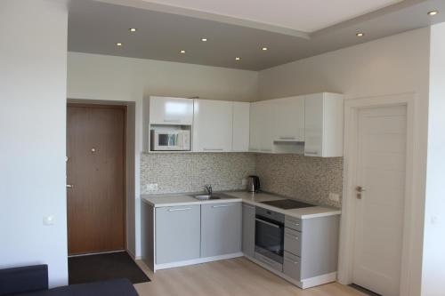uma cozinha com armários brancos e um lavatório em Kaunas Center Apartments - K. Mindaugo g. em Kaunas