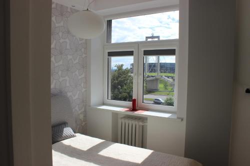 a bedroom with a bed and a window with a view at Kaunas Center Apartments - K. Mindaugo g. in Kaunas