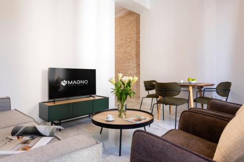 a living room with a couch and a tv at Magno Apartments San Gil - Shared Jacuzzi in Seville
