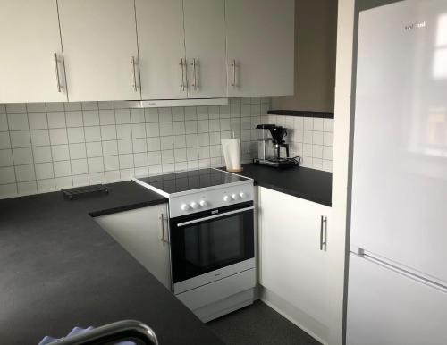 a kitchen with white cabinets and a stove top oven at Feriecentret Østersø Færgegård in Kalvehave