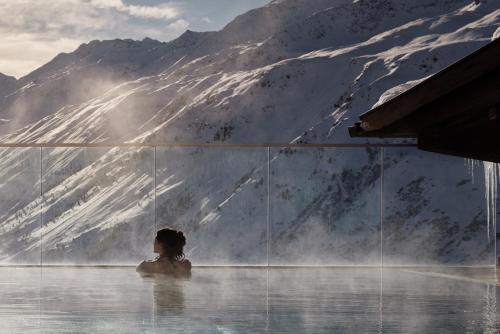 a woman sitting in a bath tub in the mountains at TOP Hotel Hochgurgl in Hochgurgl