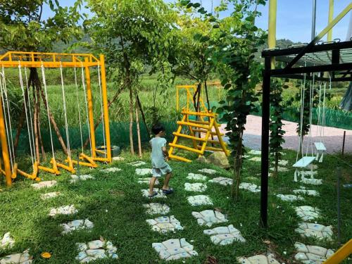 a young boy is standing in a playground at Meliora Ba Vi Homestay in Ba Vì