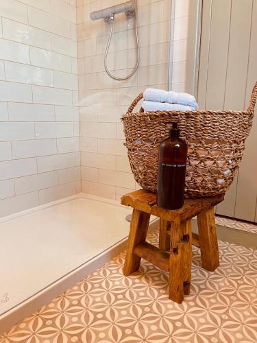 a bottle of wine sitting on a stool in a bathroom at The Cottage, Yew Tree Farm Holidays, Tattenhall, Chester in Tattenhall