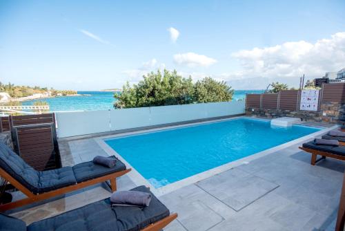 einen Pool mit Blick auf das Wasser in der Unterkunft Ammos Lux Apartments Crete in Agios Nikolaos