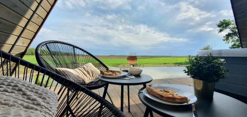 una mesa con dos rebanadas de pizza y una copa de vino en Héthatár Wellness Vendégház - Gerle, en Pusztavacs