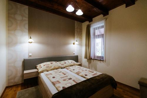 a bedroom with a bed and a window at Németh Apartmanházak in Mórahalom