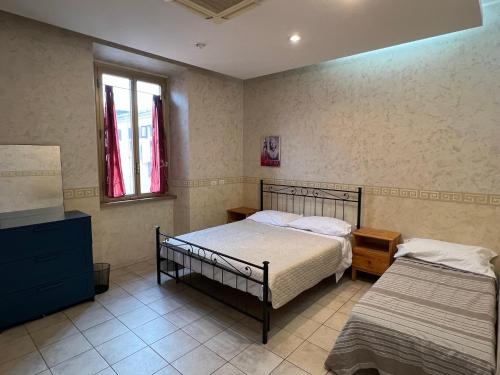 a bedroom with two beds and a dresser and two windows at Be Your Home - Casa Vacanze Il Conservatorio in Civitavecchia