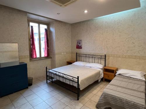 a bedroom with two beds and a dresser and two windows at Casa Vacanze Il Conservatorio - by Be Your Home in Civitavecchia